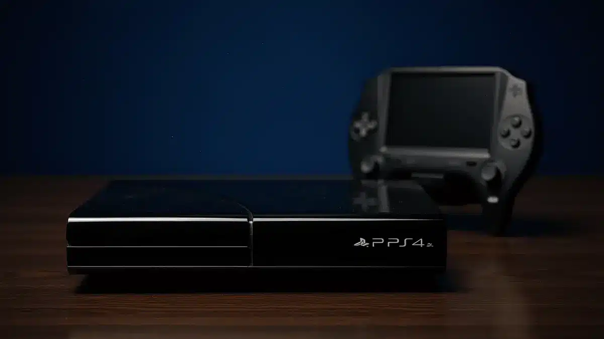 PlayStation 3 console and PS Vita handheld with inactive screens in dramatic lighting